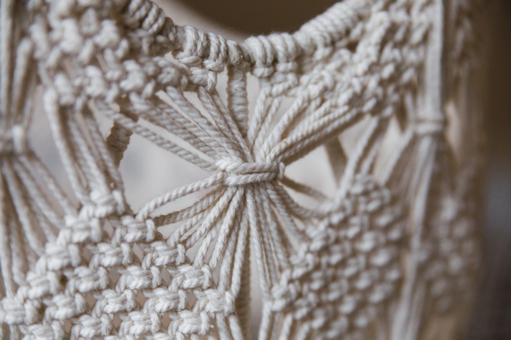 [Image Description: close image of white cord macrame basket.]
