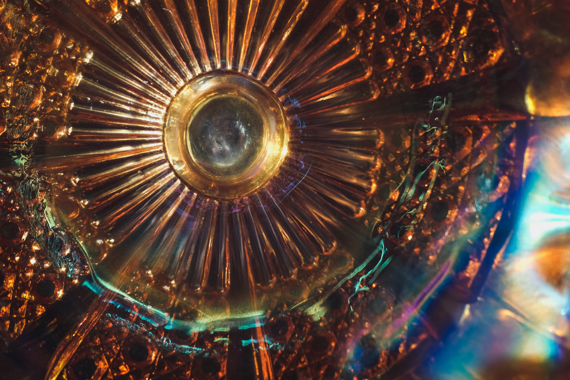 [Image Description: a carnival glass bowl with multi-coloured light reflecting through the grooves and edges.]